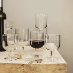 Bormioli Rocco Hosteria Medium Wine glass holding red wine in a lifestyle scene with other stemware on a white marble table