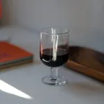 Hosteria Goblet 345ml in use with red wine, showing the clear glass bowl and short stem on a table.