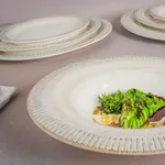 Bonna Galata Round Coupe Bowl in use, close-up of cream ceramic with ribbed rim holding grilled vegetables