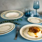 Bonna Tranquil Oval Coupe Platter 190mm in use, holding meat pie on a blue tablecloth with matching plates and glassware.