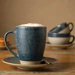 Grey Cast Espresso Saucer in use with a matching mug and copper spoon on a wooden table