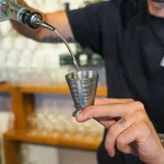D-Still Multi Level Jigger 75ml Vintage Stainless Steel in use, catching a pour from a bottle spout