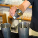 D-Still Multi Level Jigger 75ml Vintage Stainless Steel in use, pouring liquid into a mixing tin