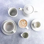 Moda Porcelain Willow Coffee and Tea Cup set in use, featuring matte white porcelain pieces with latte art