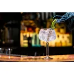 Libbey Modern America Nick & Nora glass in use with ice and rosemary garnish on a wooden bar