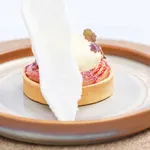 Urban Loft Auburn Oval Serve Platter close-up in use, featuring a terracotta rim and grey speckled centre holding a cream-topped tart.