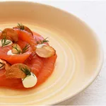 Urban Loft Sandstone Sauce Dish in use, close-up of the matte speckled ceramic bowl holding a salmon dish with dill and potato crisps.