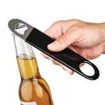 Olympia Bottle Opener Black PVC Grip in use, close-up of hand prying crown cap with silver metal head