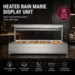 Bonvue BM17TC angled bain marie in a restaurant setting, featuring a stainless steel base, four GN pans, and a curved glass sneeze guard.