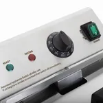 Close-up of the Apuro Induction Fryer's stainless steel control panel featuring a black rotary dial, indicator lights, and a green power switch.
