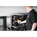 Apuro convection oven with steam in use, door open to reveal pastries on a rack, featuring a stainless steel body and visible interior fan.
