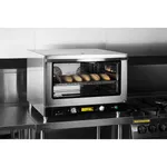 Apuro convection oven in use with door open, revealing bread loaves on a wire rack and two interior fans.