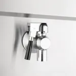 Close-up of the Apuro Double Induction Fryer's polished stainless steel tap with a black lever handle and circular mounting flange.