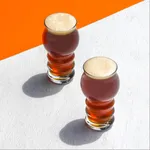 Pasabahce tin can cocktail glasses filled with amber drink and foam, viewed from a high angle