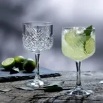 Close-up of two Pasabahce Timeless Nick & Nora glasses, one empty showing cut crystal stems and one filled with a green cocktail.
