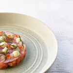 Urban Loft Pistachio Oval Serve Platter close-up in use with salmon tartare, showing pale green speckled ceramic and concentric ridged rings.