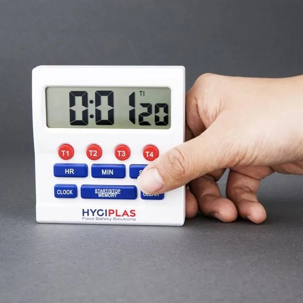 Close-up of the Hygiplas Big Digit Timer in use, showing a hand pressing the blue SET button on the white plastic casing.