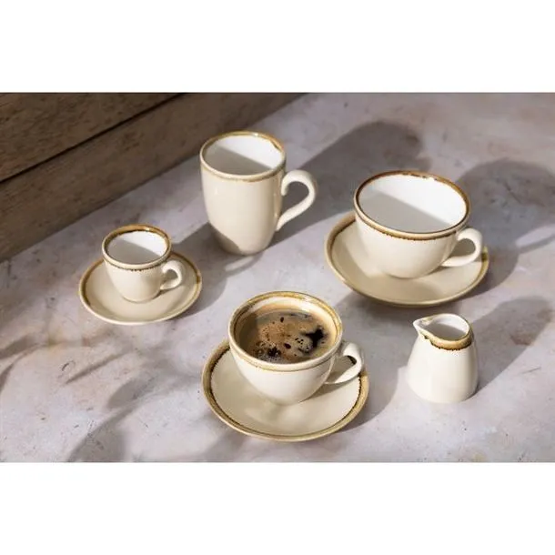 Olympia Kiln Sandstone Saucer in use with cream ceramic tableware, featuring a wide flat profile and gold rim.