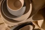 Overhead close-up of nested Luzerne Share Bowls in cream, grey, and beige speckled ceramic with matte glaze and rounded rims.