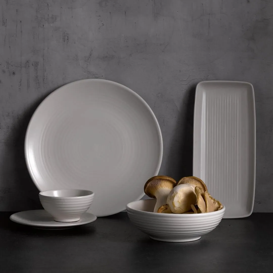 Dudson Round Bowl in white ribbed ceramic, shown in use filled with shiitake mushrooms on a dark surface.