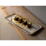 Dudson Rect Coupe Plate in use, holding four cone-shaped appetizers on a rustic wooden board, showing its white glaze and brown rim.