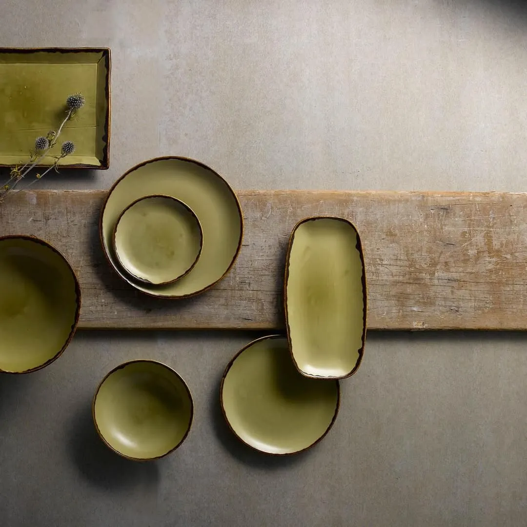 Overhead view of the Dudson Round Coupe Plate nested in a larger plate, part of an olive-green ceramic set with dark brown rims.