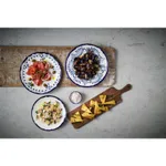 Dudson Organic Coupe plates in use, showing white ceramic with blue floral pattern and rim, filled with food on a wooden board.