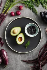 Luzerne Midnight share bowl in use, holding avocado and beans, with matte black ceramic and cream rim.