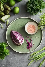 Luzerne Smokey Basil round stackable plate in use, holding red cabbage and pink salt on a grey stone surface.