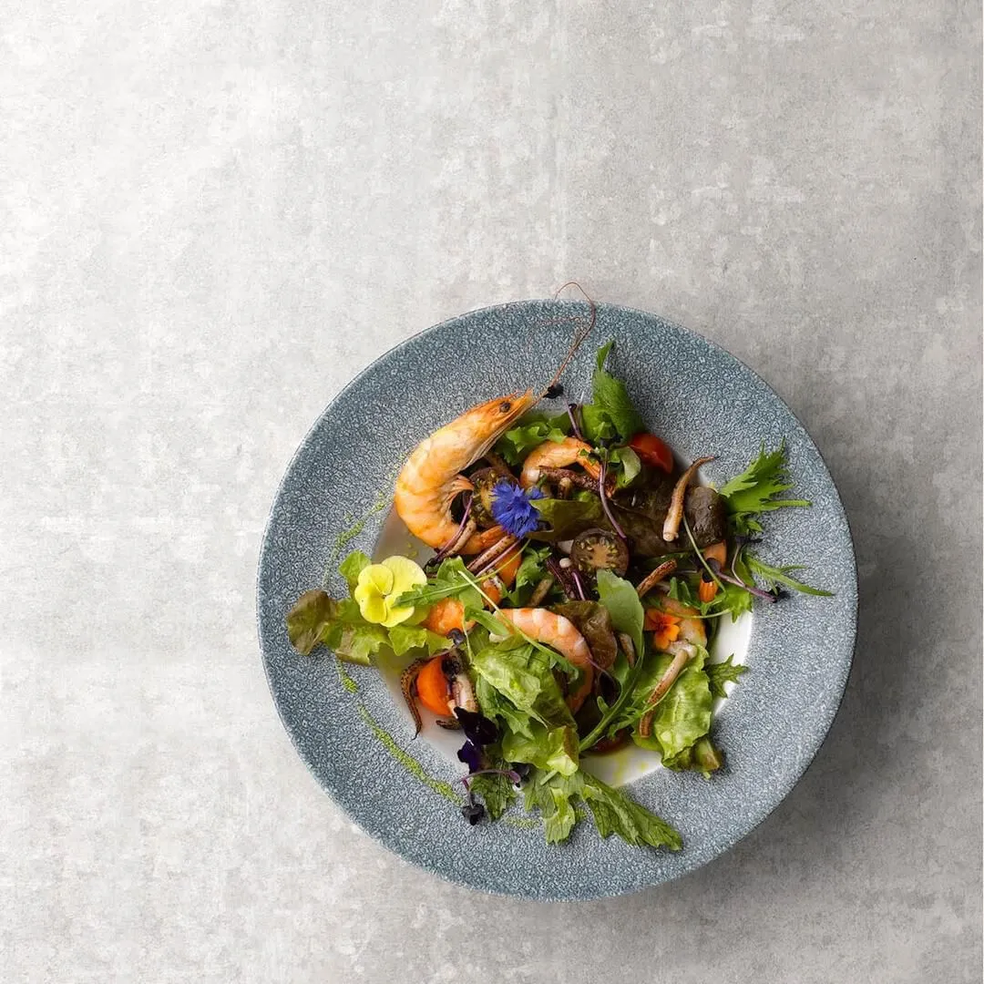Churchill Round Wide Rim Bowl in speckled grey-blue ceramic, overhead view filled with seafood salad