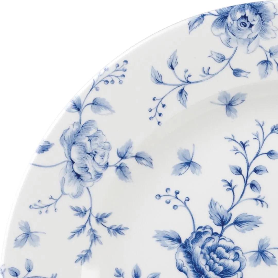 Close-up of the curved rim and inner surface of the Churchill Round Plate-305mm, featuring blue hand-painted style rose and vine motifs on white ceramic.